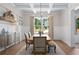 Elegant dining room featuring a coffered ceiling, modern chandelier, and classic wainscoting at 3790 Chattahoochee (Lot 33) Rd, Cumming, GA 30041