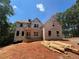 Exterior of a two-story new home under construction set amongst mature trees at 3790 Chattahoochee (Lot 33) Rd, Cumming, GA 30041