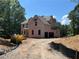 Two-story home under construction featuring an unfinished gravel driveway and wooded backdrop at 3790 Chattahoochee (Lot 33) Rd, Cumming, GA 30041
