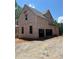 Side view of a new home under construction showing the framed garage and partially completed exterior at 3790 Chattahoochee (Lot 33) Rd, Cumming, GA 30041