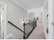 Upstairs hallway with black railing, leading to bedrooms and featuring built-in shelving at 3790 Chattahoochee (Lot 33) Rd, Cumming, GA 30041