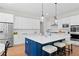 Bright kitchen with white cabinets, stainless steel appliances, quartz countertop island, and hardwood flooring at 3790 Chattahoochee (Lot 33) Rd, Cumming, GA 30041