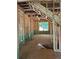 Unfinished living room featuring wooden flooring and stairwell cutout. Framing for custom window placement at 3790 Chattahoochee (Lot 33) Rd, Cumming, GA 30041