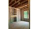 Living room under construction featuring wood framing, fireplace and view of the backyard through the windows at 3790 Chattahoochee (Lot 33) Rd, Cumming, GA 30041