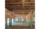 Spacious unfinished living room displaying a wooden frame, and light-filled windows at 3790 Chattahoochee (Lot 33) Rd, Cumming, GA 30041