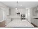 Modern kitchen with a marble island, stainless steel appliances, and white cabinetry at 3790 Chattahoochee Rd, Cumming, GA 30041