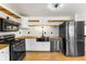 Modern kitchen with black appliances, white cabinets, wood countertops, and open shelving at 71 Riverside Ct, Douglasville, GA 30134