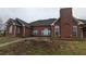 The back exterior of the brick home features a chimney and an extended patio at 1205 Peeksville Rd, Locust Grove, GA 30248