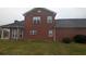 Rear view of a brick home featuring multiple windows and updated gutters at 1205 Peeksville Rd, Locust Grove, GA 30248