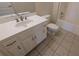 Clean bathroom featuring a white vanity, toilet, and bathtub, complemented by neutral tile flooring for a functional and tidy space at 1205 Peeksville Rd, Locust Grove, GA 30248