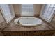 Bright bathroom featuring a luxurious white bathtub with elegant gold fixtures and beautiful tile surround, creating a relaxing atmosphere at 1205 Peeksville Rd, Locust Grove, GA 30248