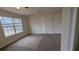 Carpeted bedroom with a large window and closet at 1205 Peeksville Rd, Locust Grove, GA 30248