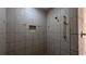 Walk-in shower with a large shelf, gold fixtures, and detailed tile work at 1205 Peeksville Rd, Locust Grove, GA 30248