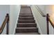 Carpeted staircase with wooden banisters, offering a classic design that seamlessly connects the different levels of the home at 1205 Peeksville Rd, Locust Grove, GA 30248