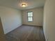 A bedroom has a window with a wooded view and neutral carpeting at 3904 Allegretto Cir # 50, Atlanta, GA 30339