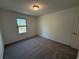 A bedroom has a window with a wooded view and neutral carpeting at 3904 Allegretto Cir # 50, Atlanta, GA 30339