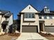 A beautiful townhome showcasing light brick and a two-car garage, set against a bright blue sky at 3904 Allegretto Cir # 50, Atlanta, GA 30339