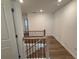 A well-lit upstairs hallway features wood floors and a wood and black iron railing at 3904 Allegretto Cir # 50, Atlanta, GA 30339