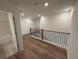 Hallway with light brown wood floors and iron railing at 3904 Allegretto Cir # 50, Atlanta, GA 30339