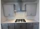 Modern kitchen with stainless steel range hood and white backsplash with gray cabinets at 3904 Allegretto Cir # 50, Atlanta, GA 30339