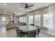 Open-concept living room with a ceiling fan, large windows, and a round dining table at 3904 Allegretto Cir # 50, Atlanta, GA 30339