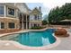 Beautiful in-ground pool with stone accents and a multi-level patio area with green foliage at 3963 Hazelhurst Lake Dr, Marietta, GA 30066