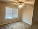 Comfortable bedroom with carpet flooring, a ceiling fan, and a window offering natural light at 4421 Fulson Dr, Lilburn, GA 30047