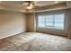 Spacious bedroom featuring plush carpeting, a ceiling fan, and a large window for natural light at 4421 Fulson Dr, Lilburn, GA 30047