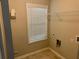 Functional laundry room with tiled flooring, a window for ventilation, and ample space for laundry appliances at 4421 Fulson Dr, Lilburn, GA 30047