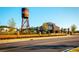 Picturesque City Center features a water tower, brick buildings, decorative fences and trees beside a public street at 5005 Crestline View Rd, Cumming, GA 30028