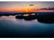 Aerial view of serene lake surrounded by lush green trees with a beautiful and peaceful sunset reflecting on water at 5005 Crestline View Rd, Cumming, GA 30028