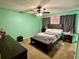 Carpeted bedroom with ceiling fan, natural light, and a neatly made bed at 1536 Hunters Cv, Auburn, GA 30011