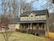 Traditional two-story house with large front porch, green grass and trees at 1536 Hunters Cv, Auburn, GA 30011