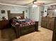 Spacious main bedroom with wooden furniture, ceiling fan, and wall decorations at 1536 Hunters Cv, Auburn, GA 30011