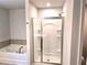 Bright bathroom featuring a soaking tub and separate glass-enclosed shower with built-in shelving at 680 Sundial Ln, Mableton, GA 30126