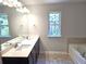 Bathroom with double sink vanity, tub, and large mirror with natural light at 680 Sundial Ln, Mableton, GA 30126