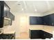 Stylish kitchen featuring dark blue cabinets, stainless steel microwave, and light countertops at 680 Sundial Ln, Mableton, GA 30126