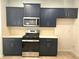 Modern kitchen with sleek, navy blue cabinetry, stainless steel appliances, and light countertops at 680 Sundial Ln, Mableton, GA 30126