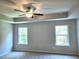 Main bedroom features a ceiling fan and two large windows with wooded view at 680 Sundial Ln, Mableton, GA 30126
