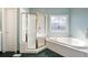 Bathroom features a glass shower and a soaking tub with a decorative stained glass window at 811 Weeping Willow Dr, Powder Springs, GA 30127