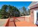 A wooden deck overlooks the lawn and wooded backyard of the house at 811 Weeping Willow Dr, Powder Springs, GA 30127