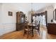 Formal dining area featuring a chandelier, hardwood floors, and a bright window at 811 Weeping Willow Dr, Powder Springs, GA 30127