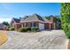 Circular driveway leads up to a brick home with a three-car garage and manicured landscaping at 811 Weeping Willow Dr, Powder Springs, GA 30127
