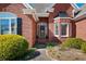 Close-up of the brick home's entrance, showcasing the door, wreath, and manicured landscaping at 811 Weeping Willow Dr, Powder Springs, GA 30127