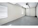Clean, empty garage with a gray concrete floor, white walls, and a white garage door at 811 Weeping Willow Dr, Powder Springs, GA 30127