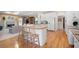 Open kitchen with white cabinets flows into a living area with fireplace and hardwood floors at 811 Weeping Willow Dr, Powder Springs, GA 30127