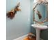 Stylish powder room with a pedestal sink, decorative mirror and soft, blue paint at 811 Weeping Willow Dr, Powder Springs, GA 30127