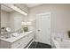 Bathroom featuring dual sinks, bathtub and dark tile flooring at 1029 Piedmont Ne Ave # 101, Atlanta, GA 30309