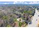 Overhead shot featuring a suburban home surrounded by lush trees, featuring a circular driveway and swimming pool at 3128 Lower Roswell Rd, Marietta, GA 30068