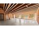 Unfinished basement showing exposed ceiling beams and framed walls, bathed in natural light at 3128 Lower Roswell Rd, Marietta, GA 30068